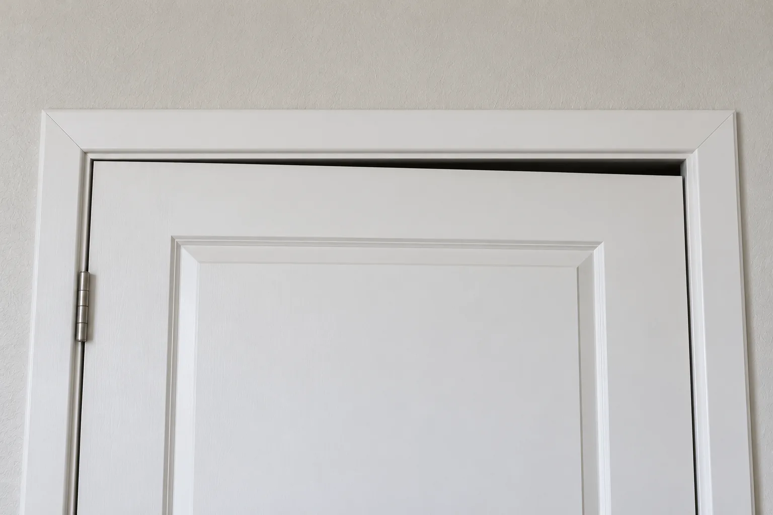 Top of an interior door with a gap above it that widens from one corner to the other